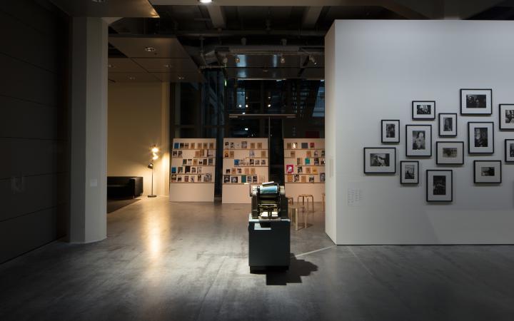 Blick in die Ausstellung »Beat Generation«: Zu sehen sind im Hintergrund einige Bücher, im Zentrum eine alte Druckmaschine und am rechten Rand mehrere Schwarz-Weiß-Fotografien
