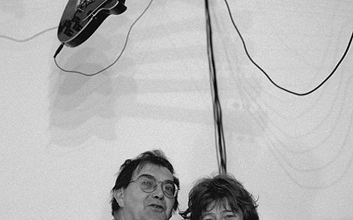 B / W photography. About two people hanging on a electric guitar.