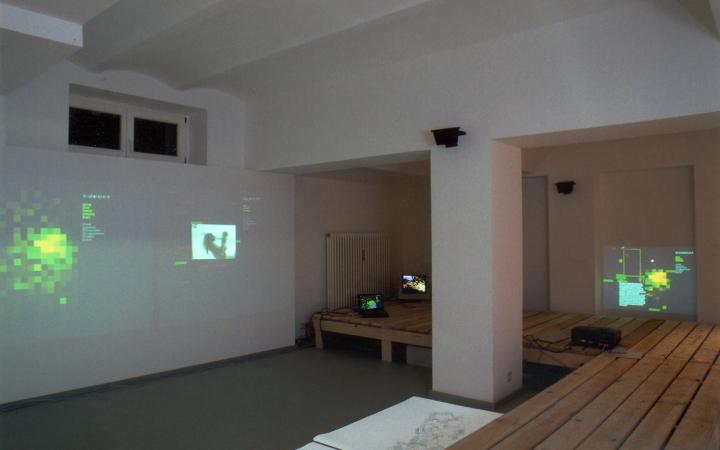 View of the exhibition space of the gallery K & S: In a space architecture made of pallets maps, pictures and films are projected.