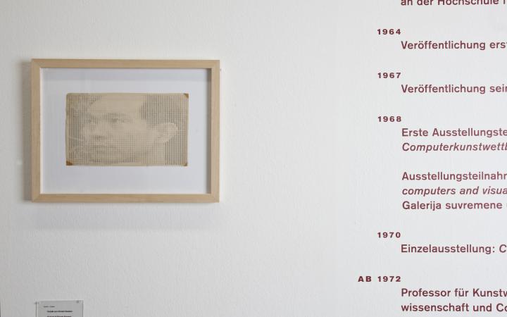 A white wall: on the left, a portrait of Hiroshi Kawano left, on the right, his resume