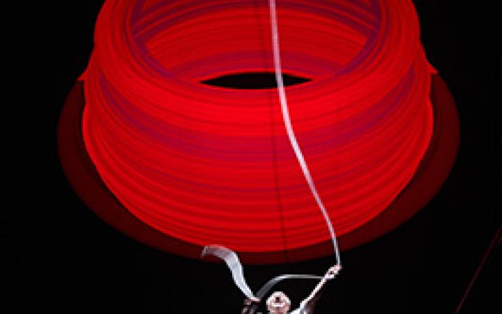 Ein großer roter Ring über einem Mann vor schwarzem Hintergrund