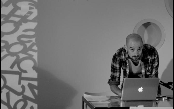 B/W photography. A man uses a laptop standing on a table.
