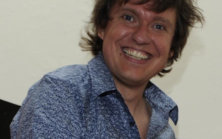 A laughing man wearing a blue shirt.