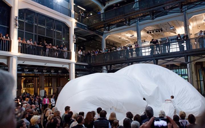Ein riesiger weißer Ballon im ZKM Foyer. Begleitet von einer Vielzahl an Zuschauern.