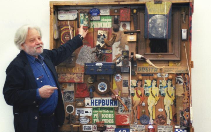 Jean-Jacques Lebel points at a collage