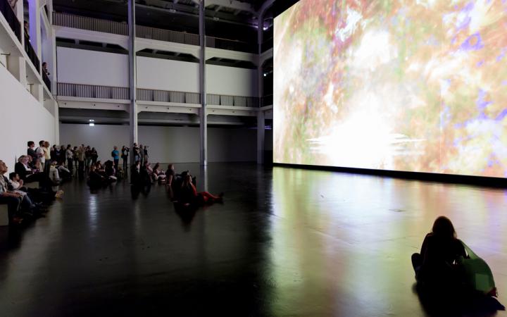 People sitting in front of a huge canvas