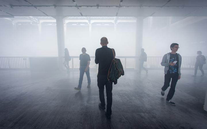Menschen laufen durch einen Nebel