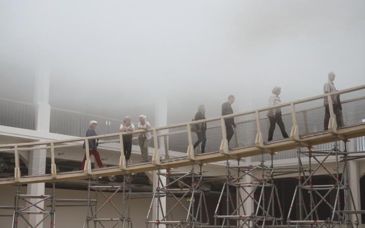 People walking via a ramp into a cloud