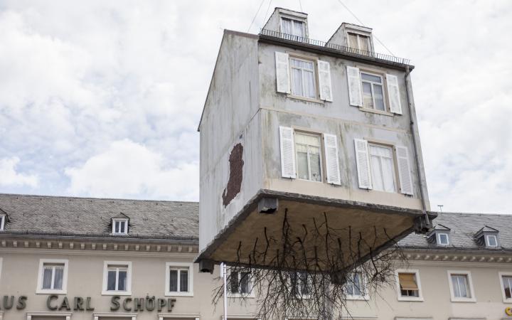 A house hangs on a crane