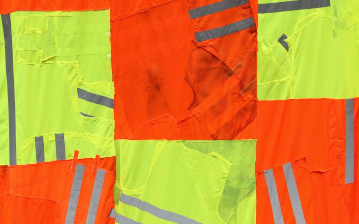 Gelber und orangener Stoff für Sicherheitswesten zusammengeknüpft zu einer drei mal 4 großen Fläche