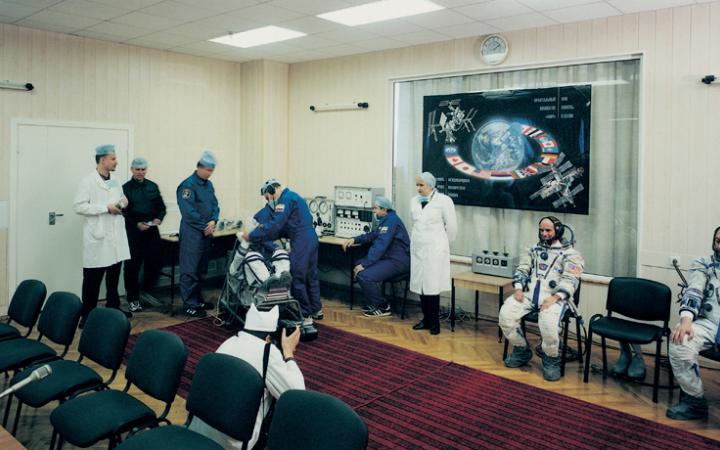 Ein Konferenzraum. Mehrere Astronauten und Mediziner.