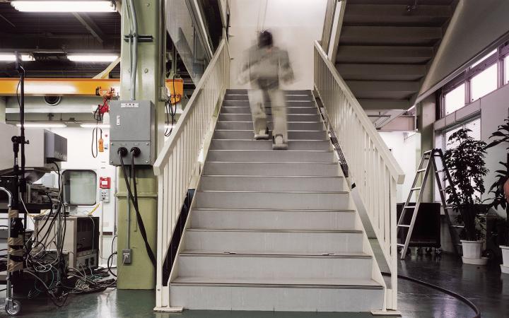 A robot walking up the stairs in an industrial building