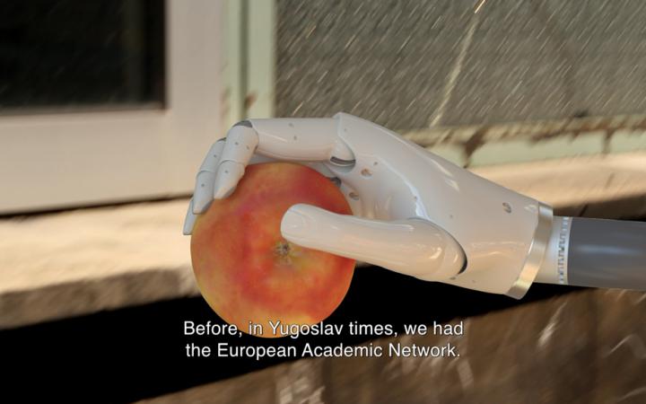 A roboter hand holds an apple