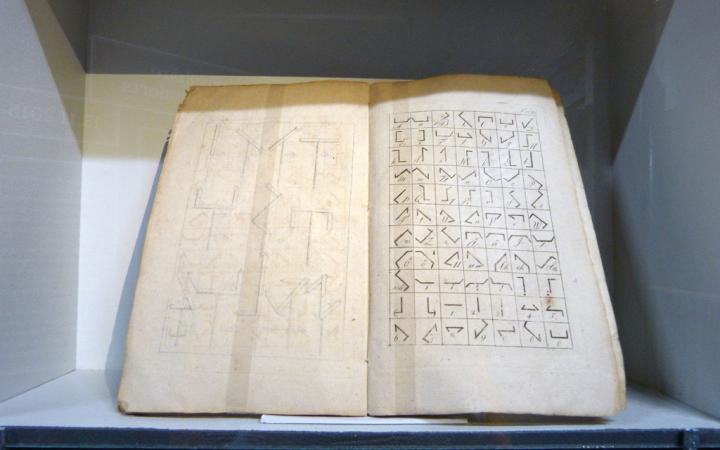 Ein altes, aufgeschlagenes Buch mit Zeichen