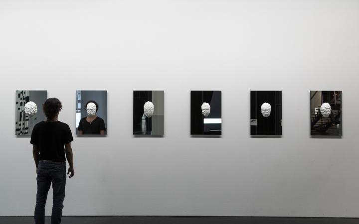 In plaster casted masks hang on mirrors