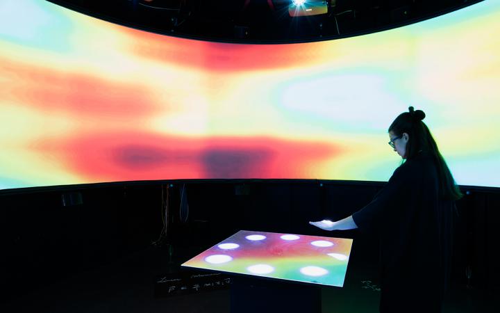 A woman interacting with a colorful panel