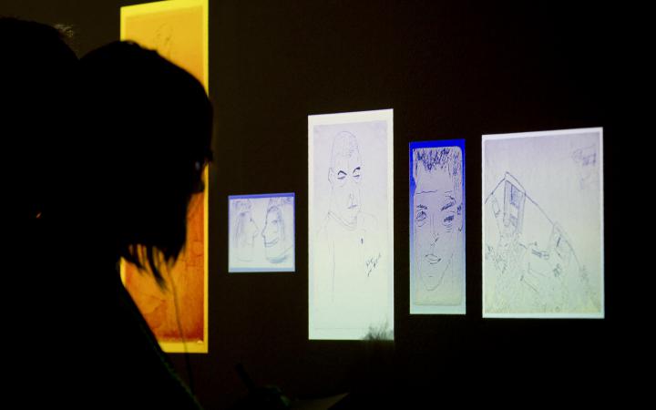 A person looks at enlightened drawings in the dark