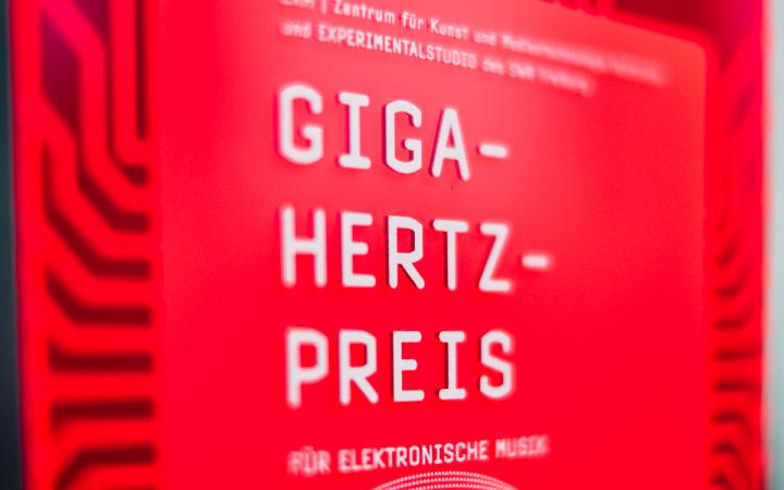 Red plaque with "Giga-Hertz-Award" in white letters