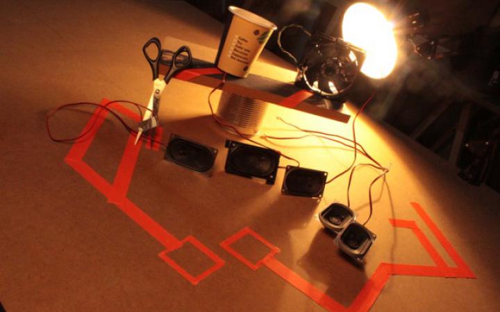 Verschiedene Lautsprecherboxen werden von einer Schreibtischlampe beleuchtet.