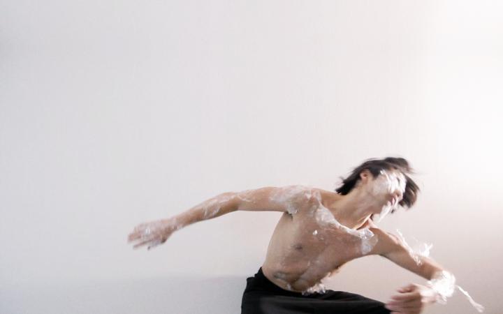 Ein Tänzer eingehüllt in Plastikfolie