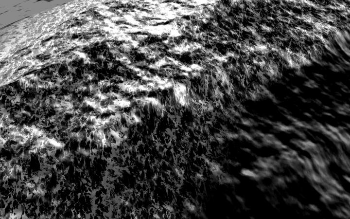 Das Bild zeigt eine schwarz-weiße Obenansicht eines bewegten Meeres. 