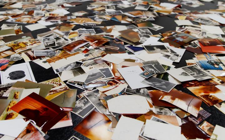 An installation by Dieter Hacker. Colored photographs are distributed on the floor of the exhibition space.