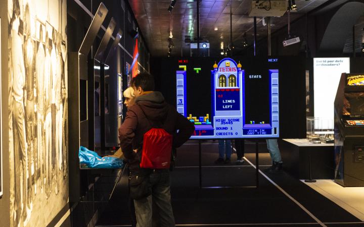 Zwei Menschen stehen vor einem Bildschirm im Ausstellungsraum »zkm_gameplay«.