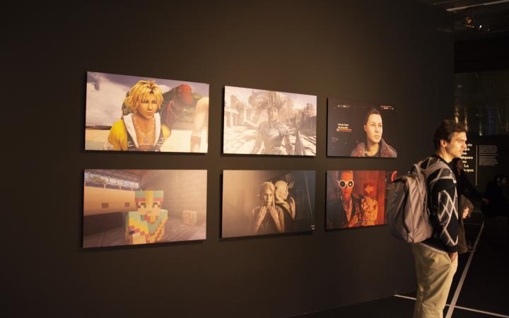 Auf der linken Seite des Bildes sind sechs Portraits von Charaktären aus verschiedenen Videospielen zu sehen. Auf der rechten Seite des Bildes steht ein Mann in grau und schwarz mit einem großen Rucksack.