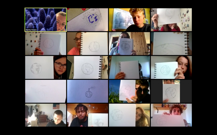 Bei diesem Bild handelt es sich um ein Bildschirmfoto, welches während eines Videocalls mit 20 Teilnehmern aufgenommen wurde. Einige Teilnehmer halten einen Zeichenblock hoch, auf dem sie eine Weltkugel skizziert haben. 