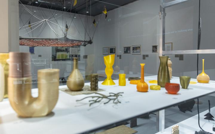Zu sehen sind mehrere Vasen-förmige Objekte auf einem Tisch.