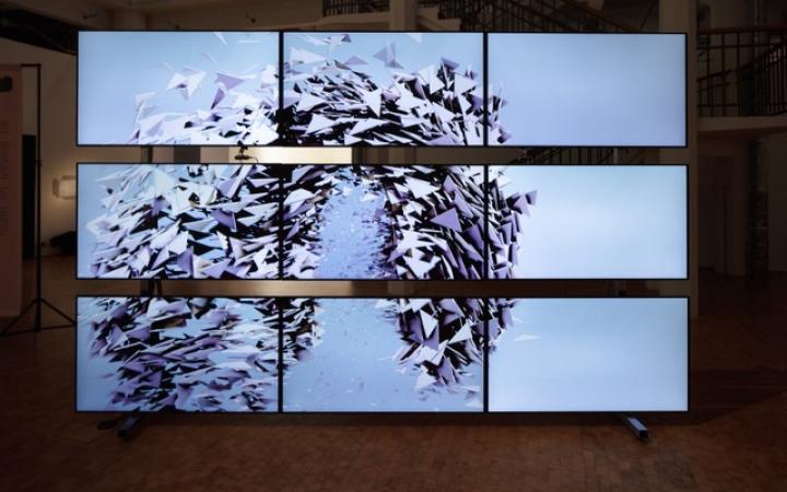 Random International, »Algorithmic Swarm Study (Triptych) / II«, 2021. The image shows new screens arranged in a rectangle. An artificial swarm can be seen on the screens.