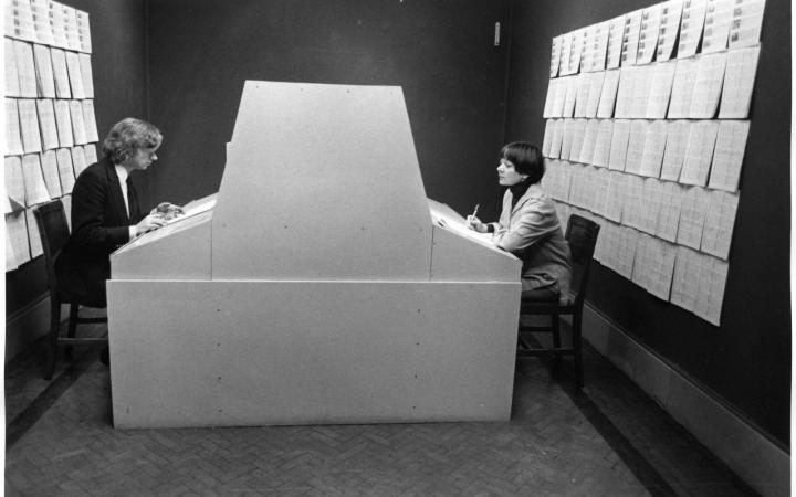 Two people working at a large computer