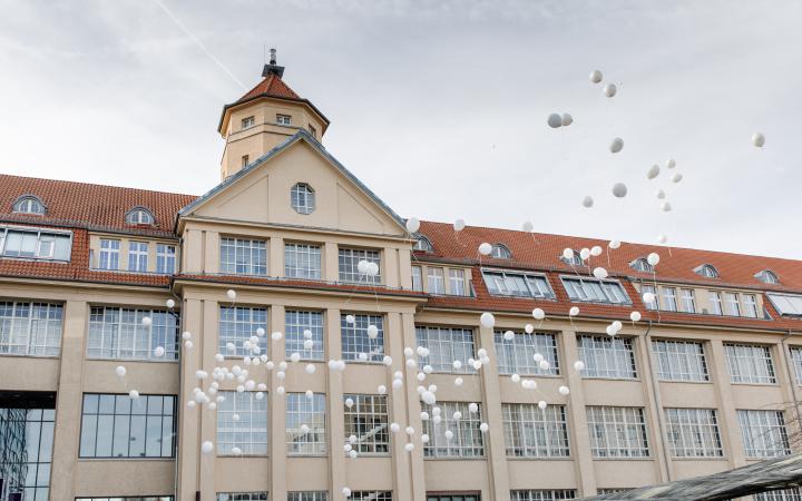 White balloons floating in front of the ZKM building.
