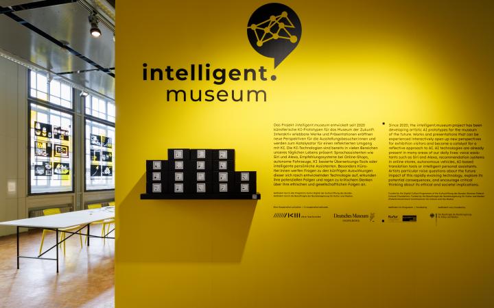 You can see a yellow wall with the logo intelligent.museum and an introductory text.