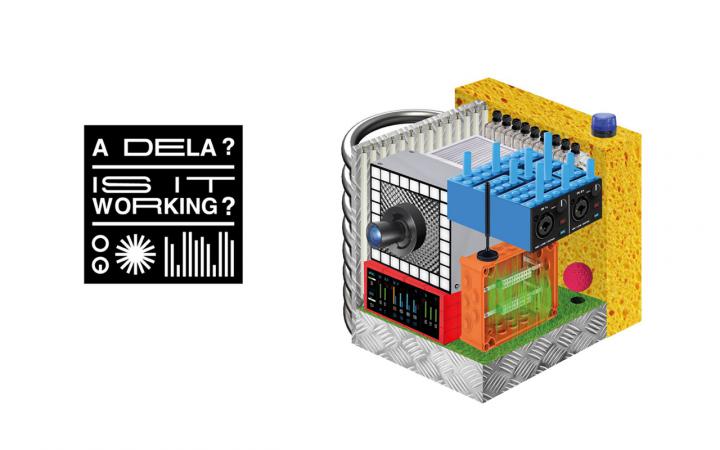 Zu sehen ist ein schwarzes Viereck, in welchem der Schriftzug A Dela? und Is it working? steht. Rechts daneben ist ein Würfel aus verschiedenen Komponenten, wie zum Beispiel einem Schwamm und eine Art Legostein zu sehen. 