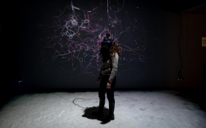 A woman wearing VR glasses in the »BioMedia« exhibition