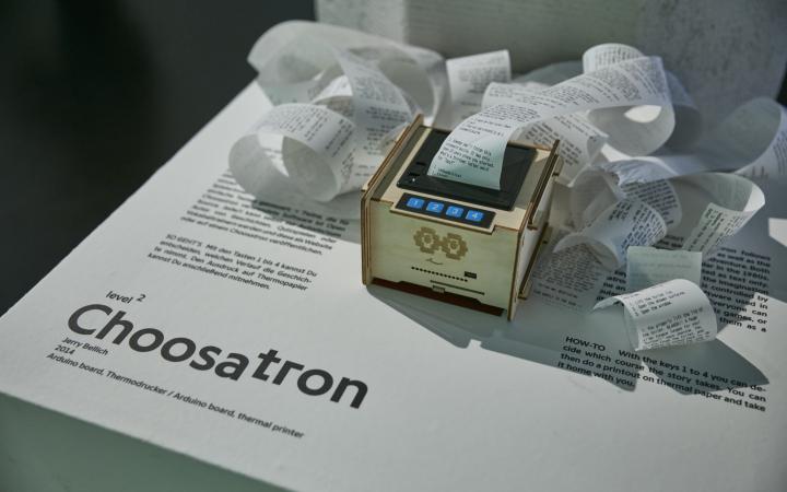 Eine Holzbox mit einem Drucker, Vier-Tasten Interface und ausgedruckten Text