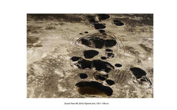 On view is the cover of the publication accompanying the exhibition Critical Zones. It shows a picture of a landscape shaped by craters. Below it is a short dialogue about how it feels to land on earth.