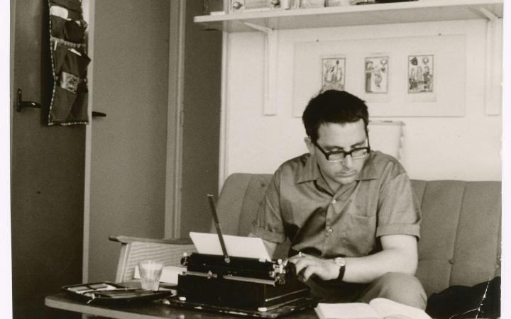 Theo Lutz sits on the couch in a study and works at the typewriter.
