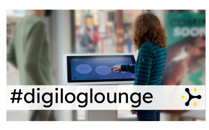 Two people at a touchscreen panel. Below is the banner "#digiloglounge"
