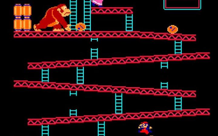 Donkey Kong lässt Fässer mehrere Stockwerke hinunterrollen. Jumpman springt über die Fässer.
