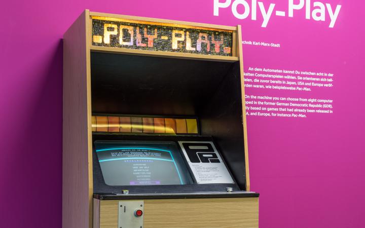Ein Arcade Automat vor einer violetten Wand