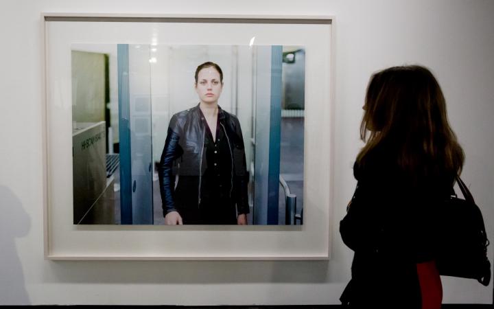 A woman ist standing in front of a photograph