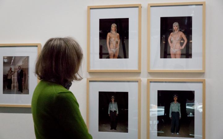 Eine Frau blickt auf mehrere Fotografien