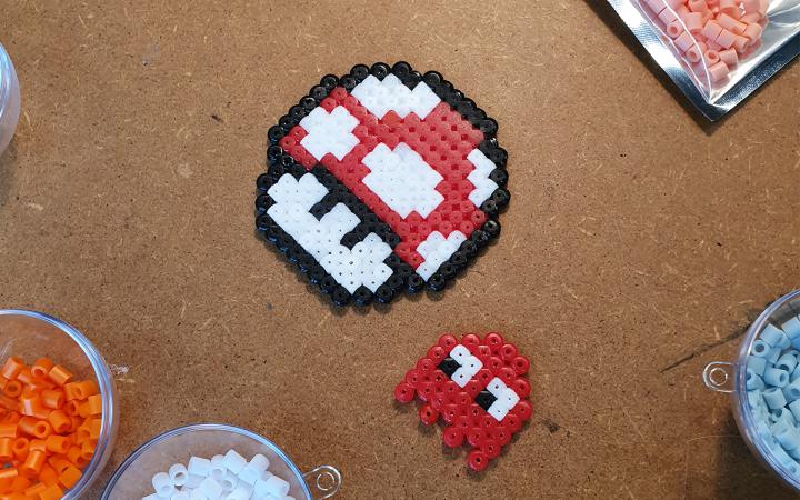 Photo of a red toadstool from Super Mario and a ghost from Pacman – both made from iron-on beads.