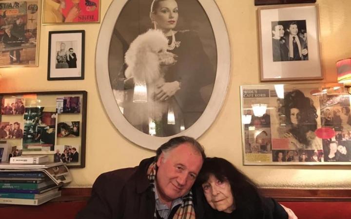 Peter Weibel with Friederike Mayröcker in front of a portrait by Susanne Widl at Café Korb, Vienna 2018.