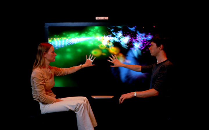 Zwei Menschen berühren einen leuchtenden Bildschirm