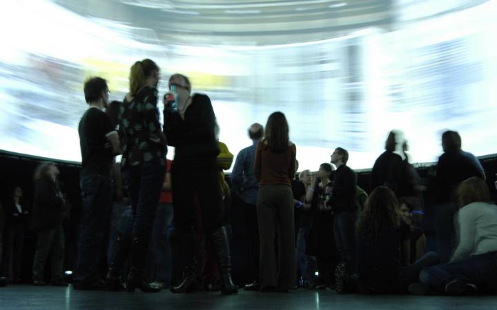 Personen stehen inmitten eines großen 360°-Bildschirms