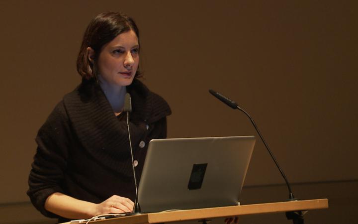 Giulia Vismara steht hinter einem Laptop und hält einen Vortrag.