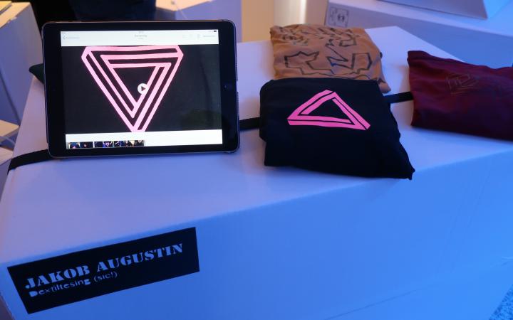 You can see an Ipad and T-shirts on a table during an event of the cultural academy.